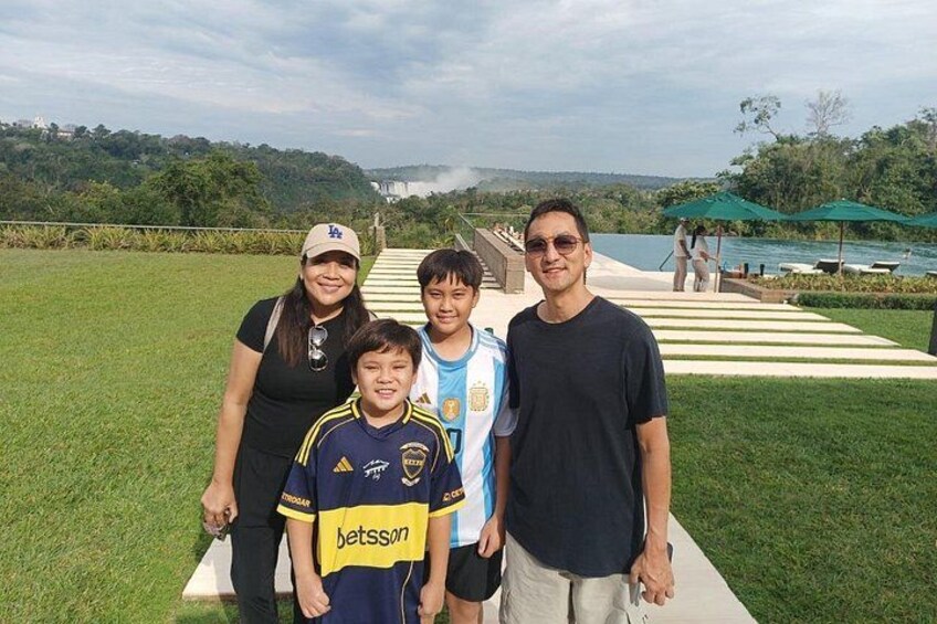 Un grupo de personas de pie en un área verde con un sendero que conduce al agua. 5