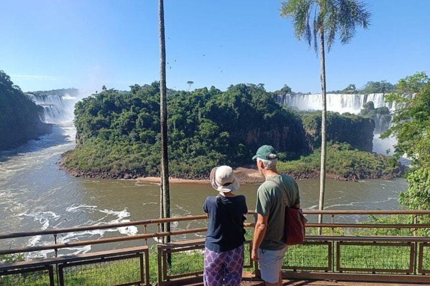 Una cascada, un río y un área boscosa con dos personas observando. 4