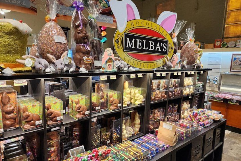 Una presentación de confitería con diversos dulces y chocolates, incluyendo conejos de chocolate y bombones envueltos. 4