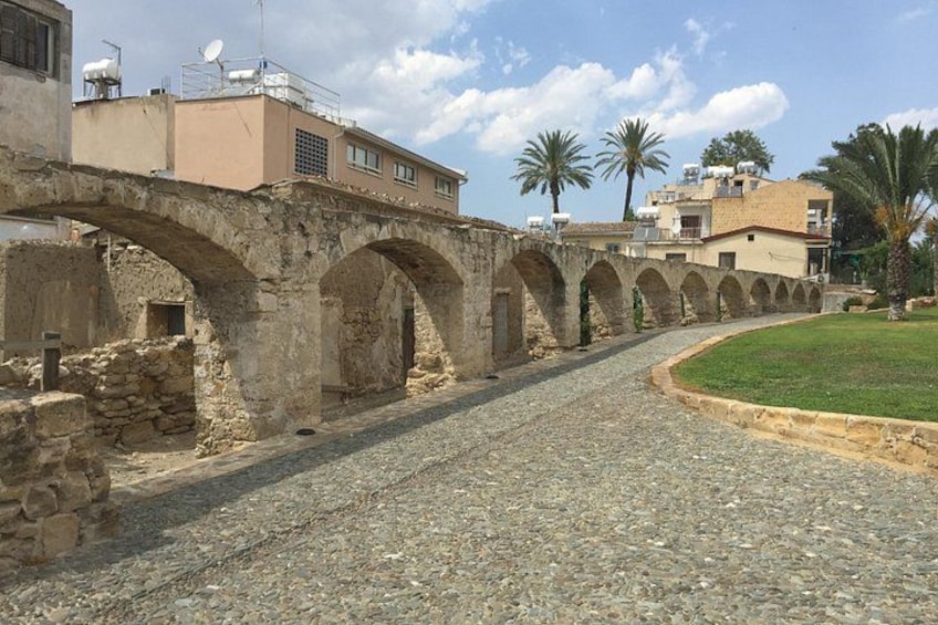 Un pont en pierre avec des arches, un chemin pavé et des bâtiments en arrière-plan. 2