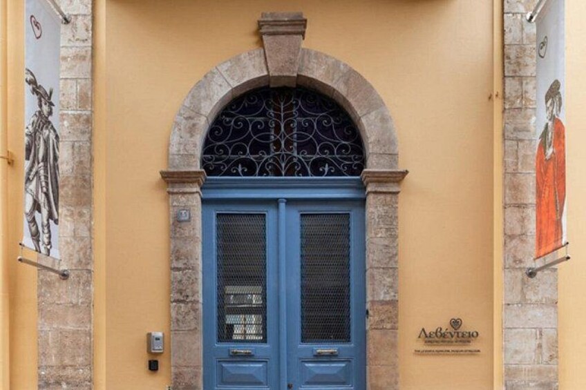 Eine blaue Tür mit dekorativem Bogen, eine Steinsäule und ein Schild mit Herzsymbol. 3