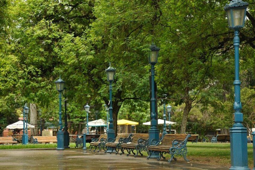 Un parc avec des lampadaires verts, des bancs et une fontaine. 5