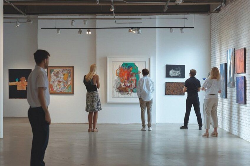 Une galerie d’art où des personnes observent des tableaux. 4