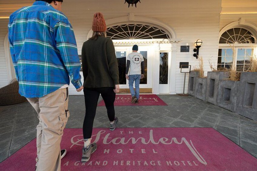 En hotelindgang med rød løber, et skilt med 'The Stanley Grand Heritage Hotel' og en person, der går mod indgangen. 2