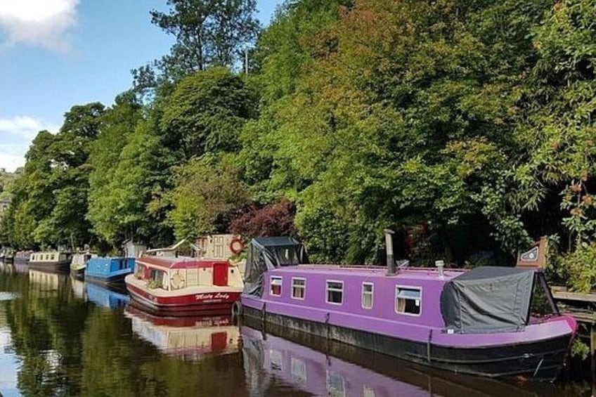 A row of colorful boats docked along a riverbank, surrounded by lush greenery. 5