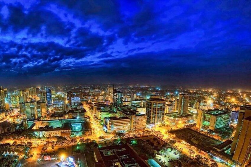 A cityscape at night with illuminated buildings and a cloudy sky. 2
