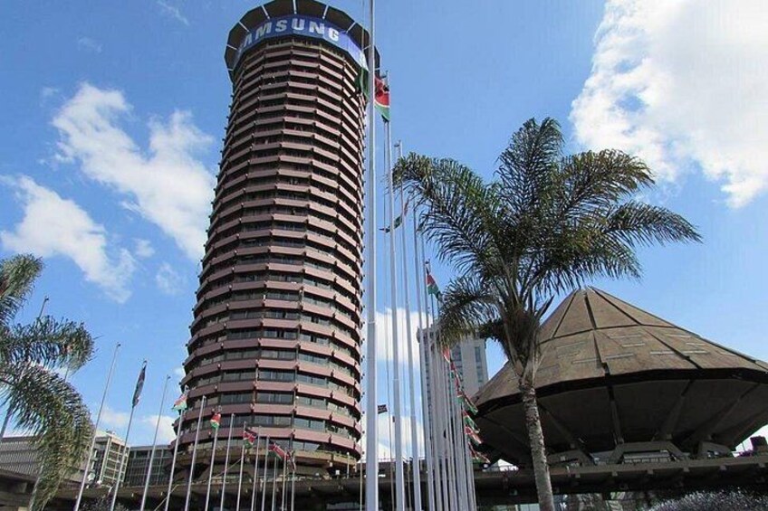 A cylindrical building with a Samsung sign, palm trees, and a covered structure. 5