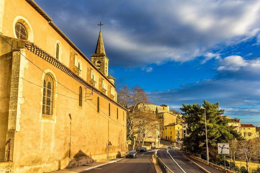 Una calle con una iglesia, cielo despejado y algunos coches. 2