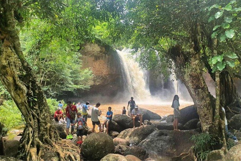A waterfall surrounded by large rocks and trees. 5