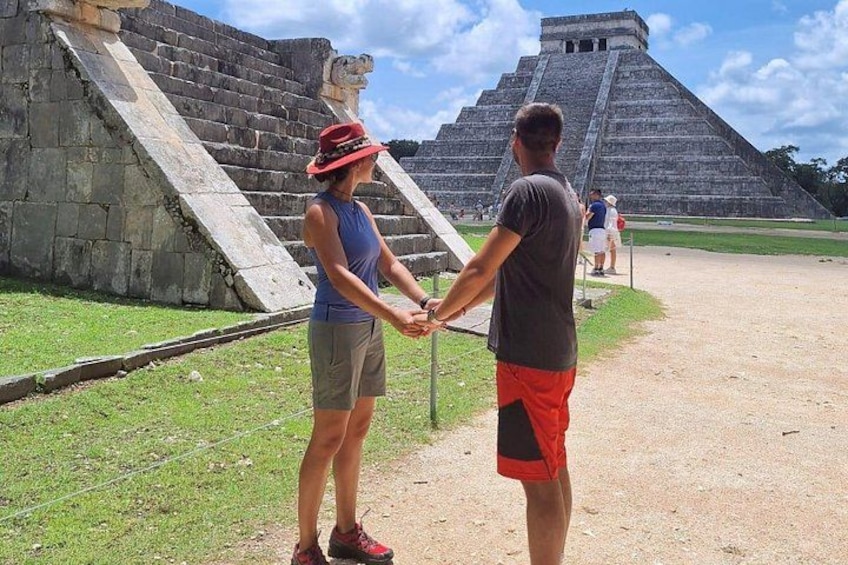 A large pyramid structure with a staircase leading up to it, surrounded by a grassy area. 2