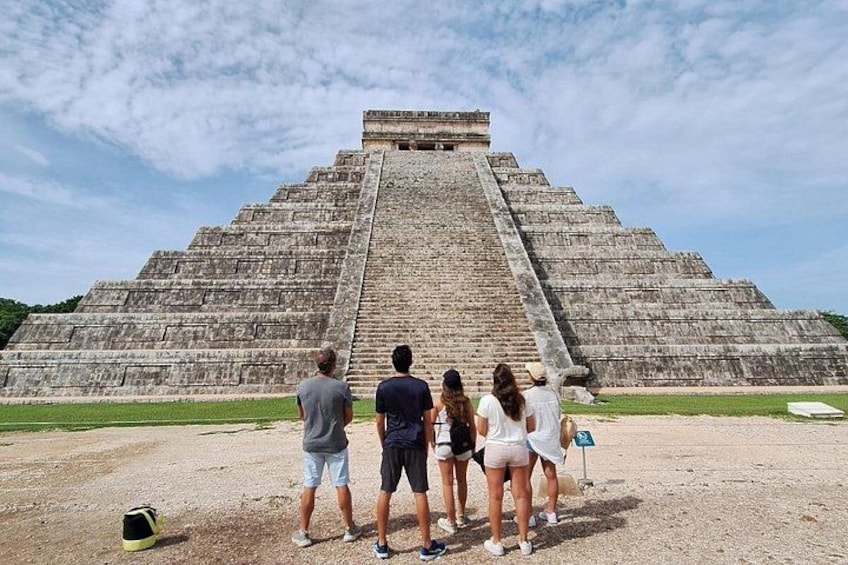 A large pyramid with tourists observing it. 4