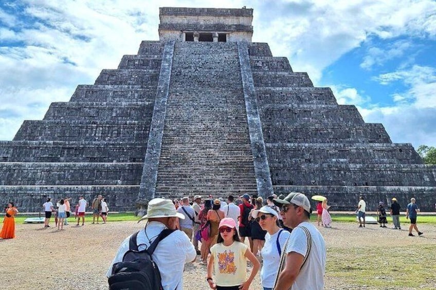 A large pyramid with tourists around it. 2