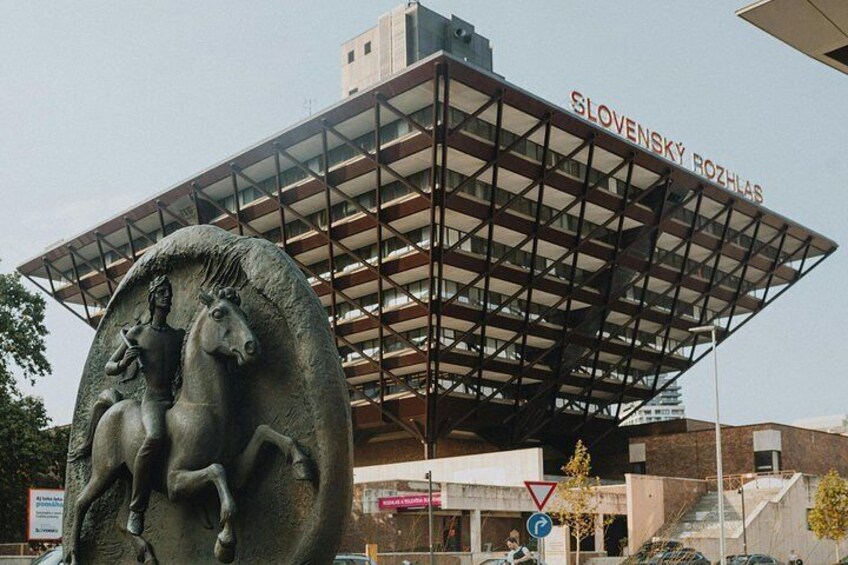Un edificio con techo metálico y una estatua de un hombre a caballo. 2