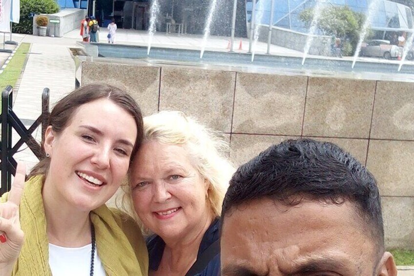Eine Gruppe von Menschen vor einem Springbrunnen mit Wasserspielen. 5