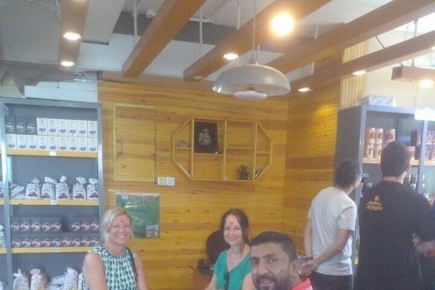Ein Restaurantinneres mit Holzwänden, hängenden Lampen und Regalen voller Speisen. 2