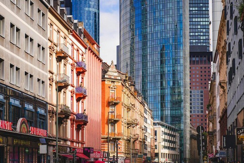 A city street lined with historic buildings and modern skyscrapers. 3