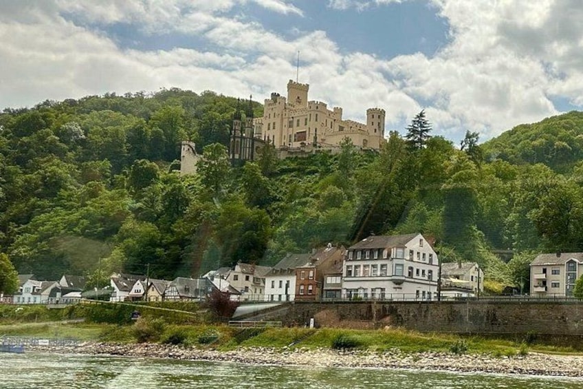 A castle on a hill, a river, and houses along the riverbank. 1