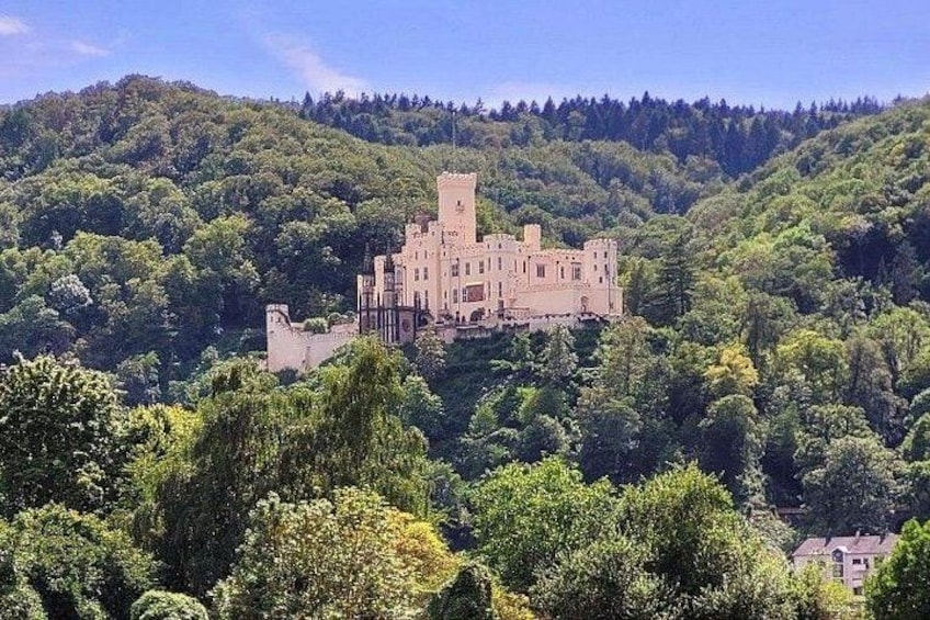 Een kasteel op een heuvel, omgeven door dicht bos. 2