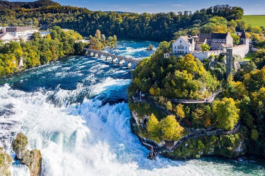 A river with a waterfall, a bridge, and a castle on a hill. 1