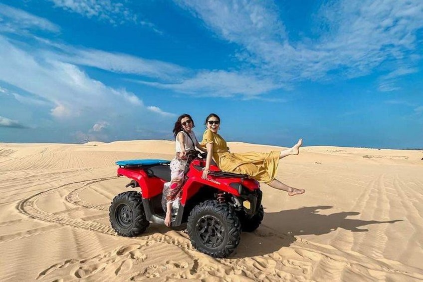 Due persone su un quad rosso in un deserto con dune di sabbia. 5
