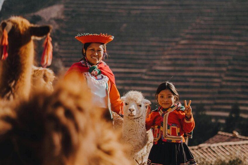A person in traditional attire with llamas. 2
