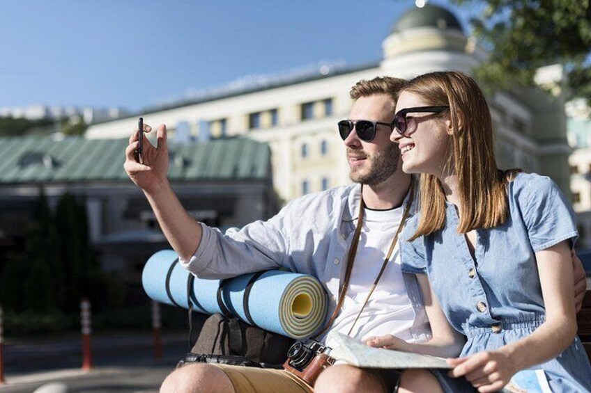 Una pareja tomándose un selfie con un paisaje urbano de fondo. 2