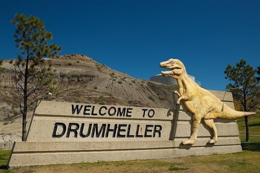 A welcome sign with a dinosaur statue at Drumheller. 3