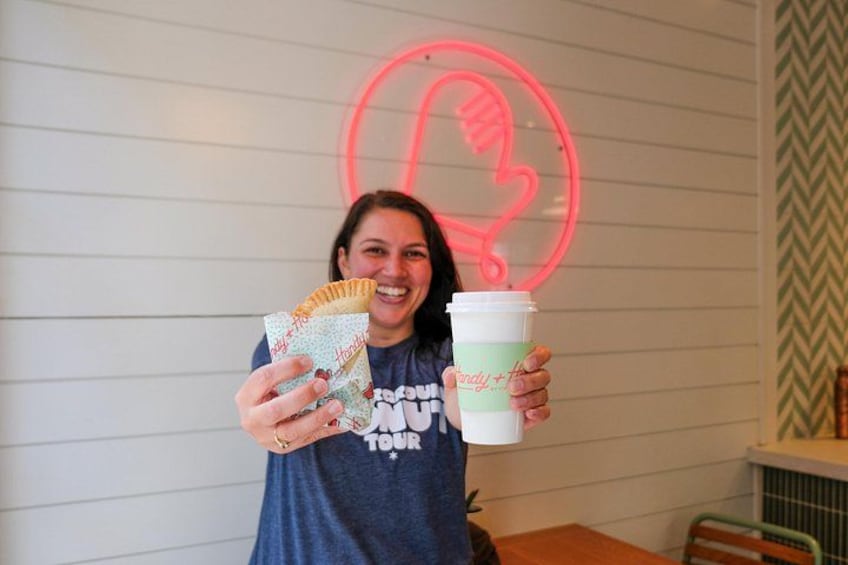 Una persona sosteniendo un pastel y una taza con un logotipo. 3