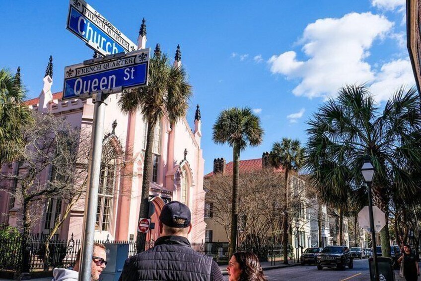 Una esquina de calle con una iglesia, palmeras y una señal de tráfico. 2