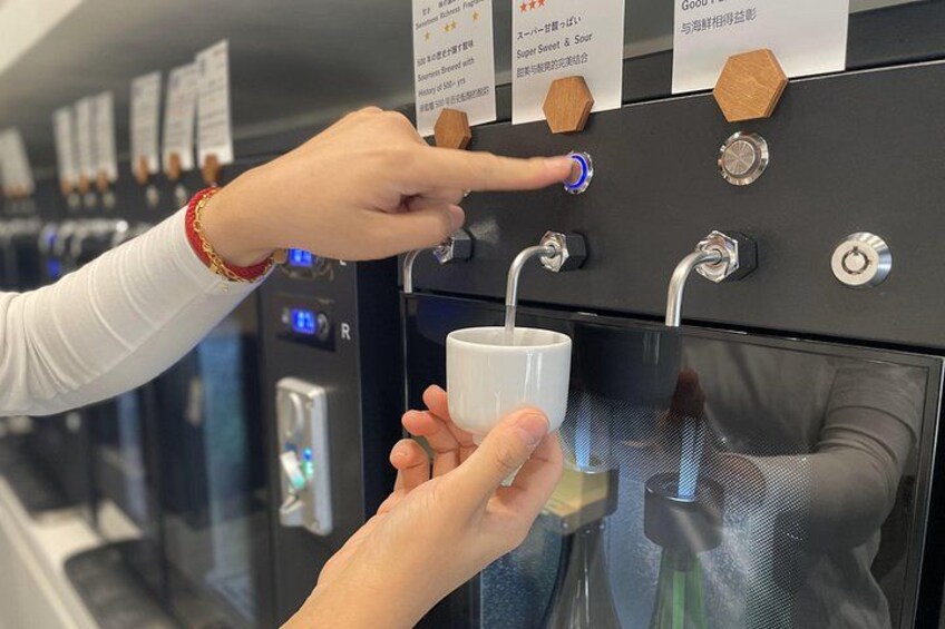 Una persona elige una bebida de una máquina expendedora de café con varias opciones. 3