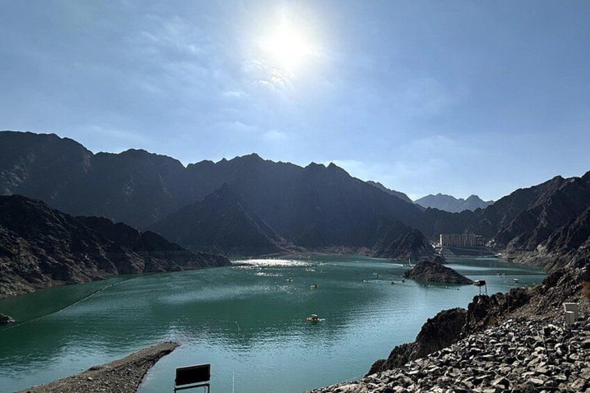A mountainous landscape with a river, a bridge, and a chair. 1