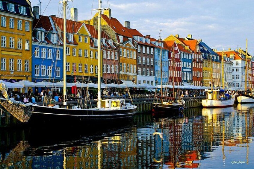 A harbor with colorful buildings, boats, and a calm water surface reflecting the architecture. 3