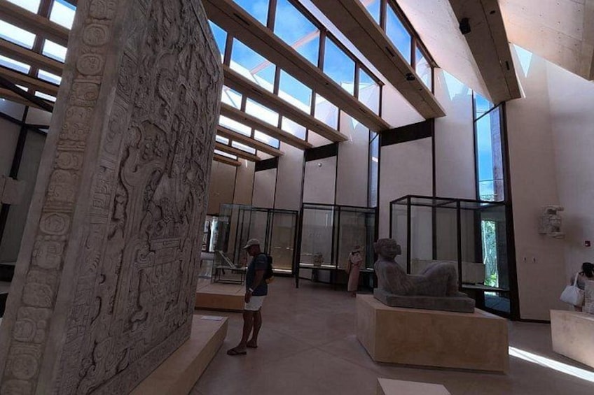 A modern interior with a large stone relief, glass partitions, and a sculpture. 2