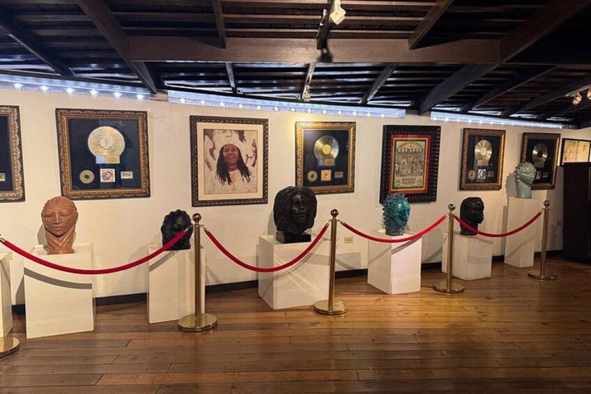 An art exhibition with framed artworks and busts on display. 2