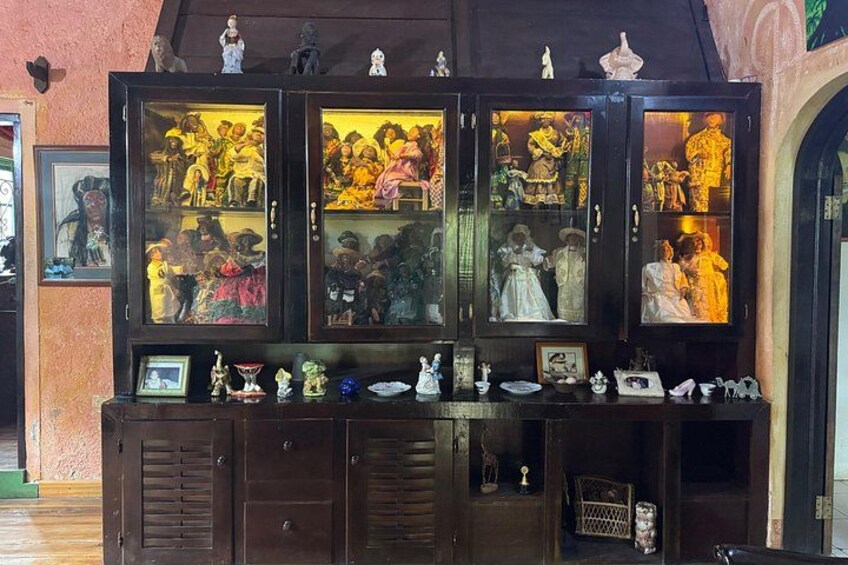 A wooden cabinet with glass doors displaying various figurines and small statues. 4