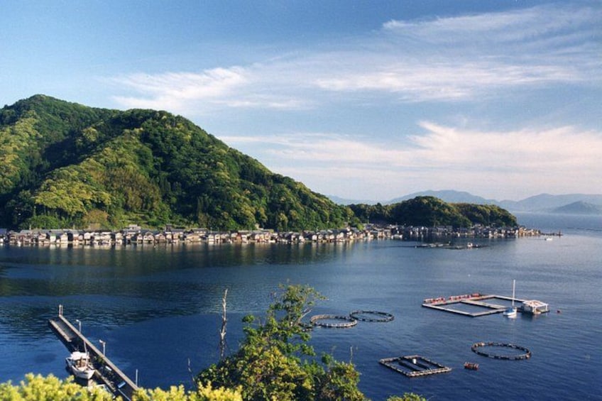 A coastal town with a dock, boats, and floating circular structures in the water. 3