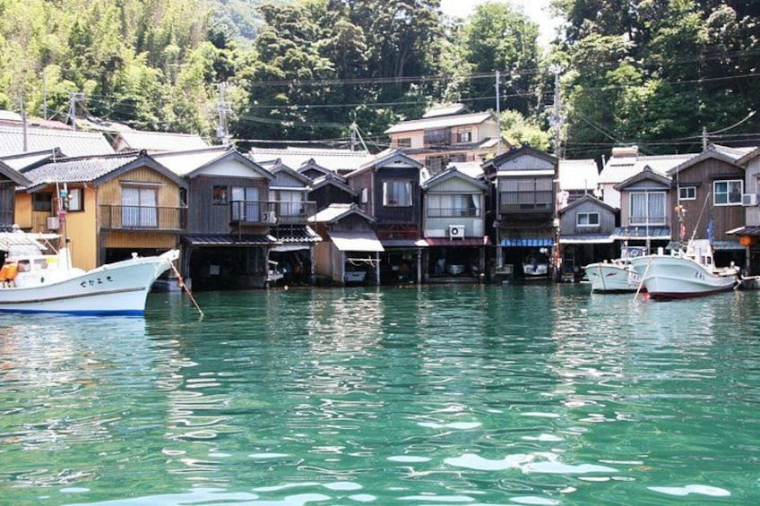 A waterfront with traditional houses and boats docked. 5