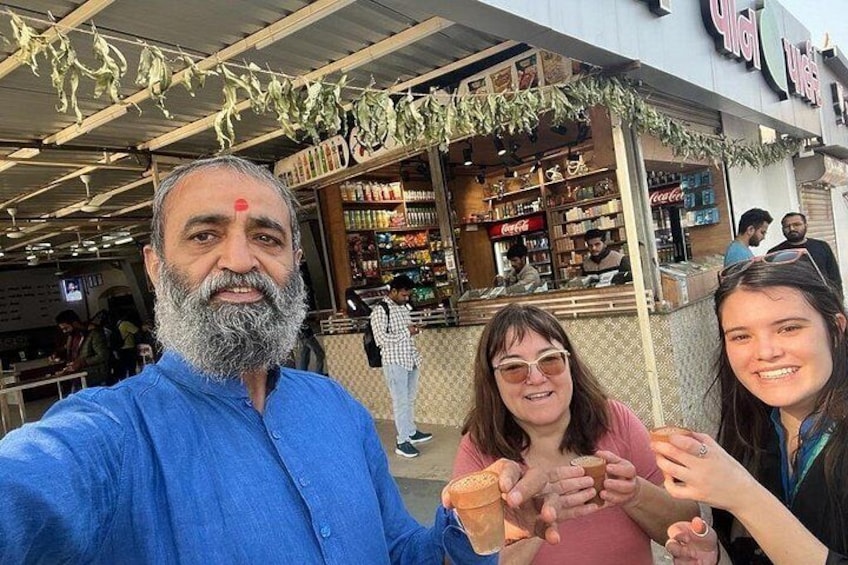 Una persona con camisa azul se toma un selfie con otras dos personas que sostienen comida. 2