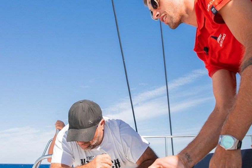Deux personnes se trouvent sur un bateau, avec un ciel dégagé en arrière-plan. 3