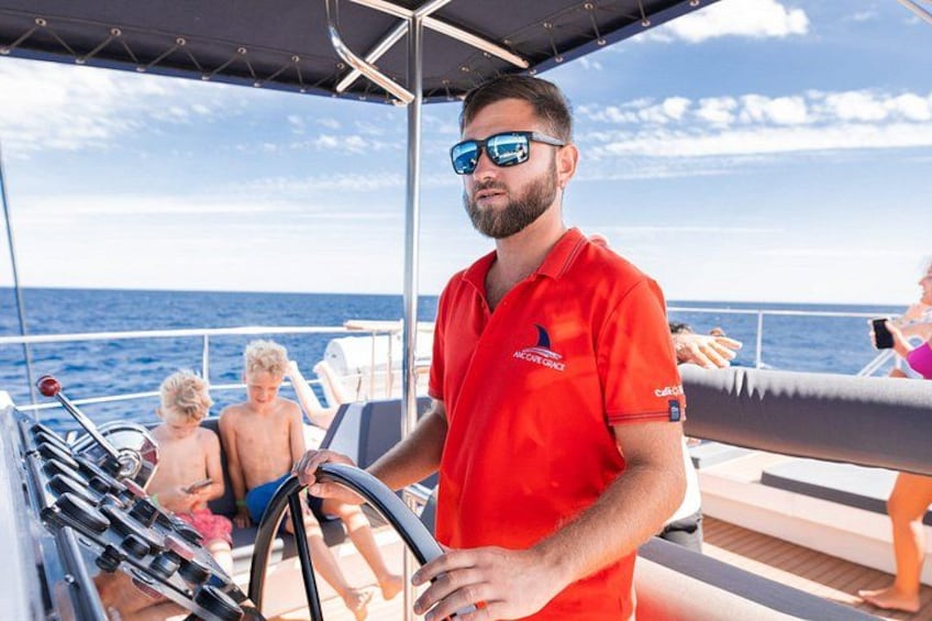 Un homme vêtu d’une chemise rouge conduit un bateau, accompagné de deux enfants et d’une femme, qui se trouvent à l’arrière-plan. 4