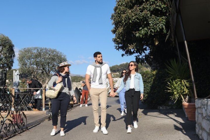 A group of people walking on a paved path surrounded by greenery and trees. 5