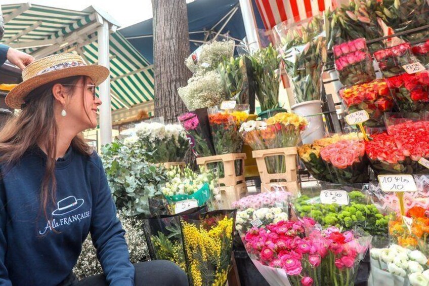 A person at a flower market with various colorful flowers and plants on display. 3