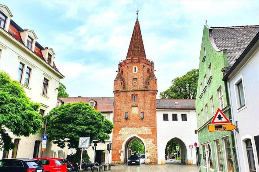Une tour historique, une église et une rue bordée de voitures et d’immeubles. 2