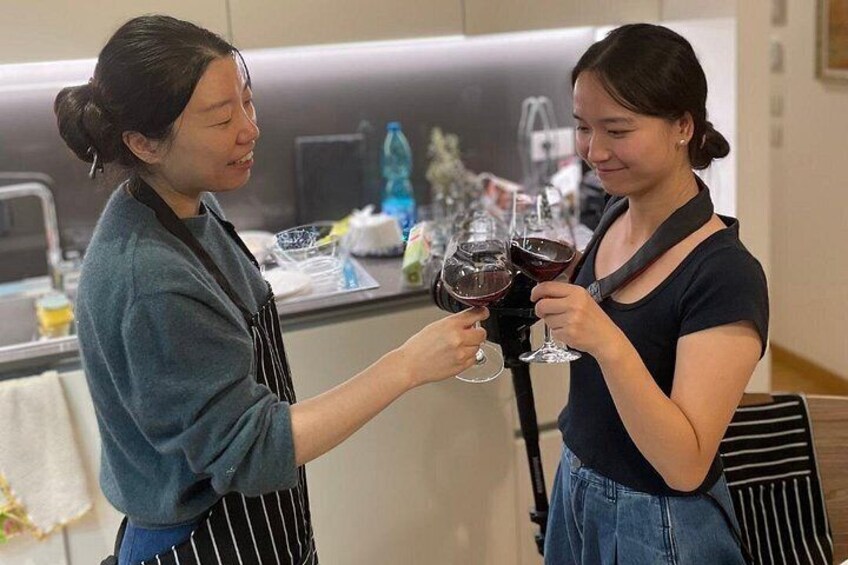 Dos personas brindando con copas de vino en una cocina. 3