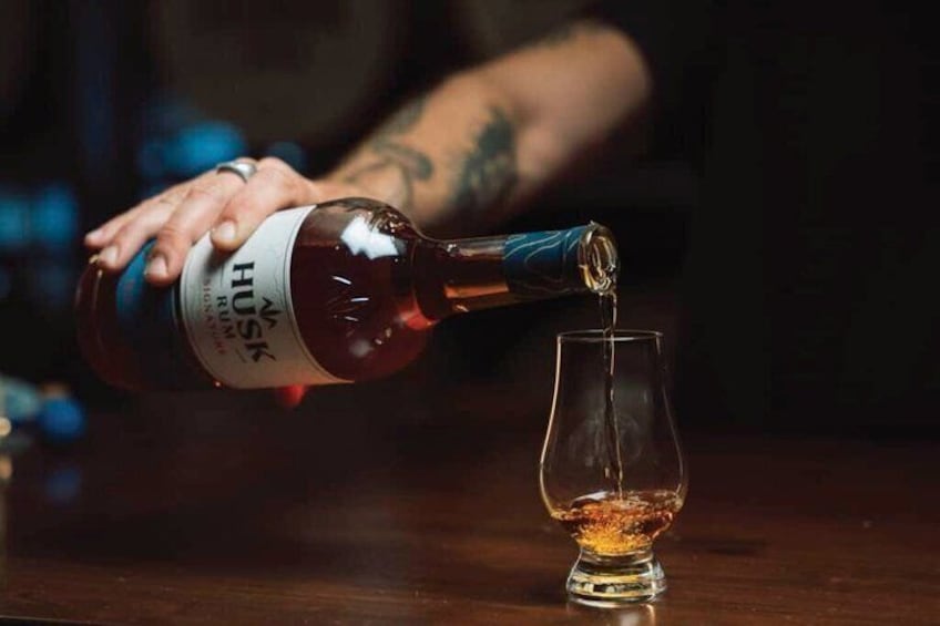 A bottle of HUSK whiskey being poured into a glass. 1