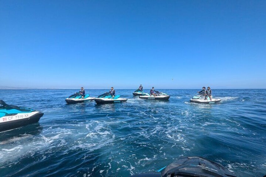 Four people jet-skiing on the ocean. 3
