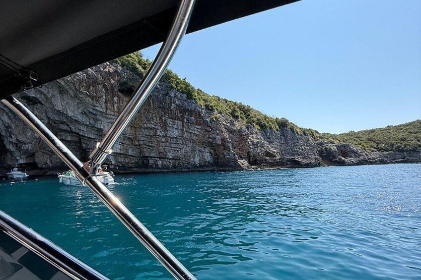 Barandilla de barco, agua tranquila y acantilados rocosos. 2