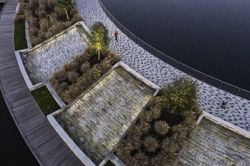 A waterfront promenade with water features and vegetation. 2