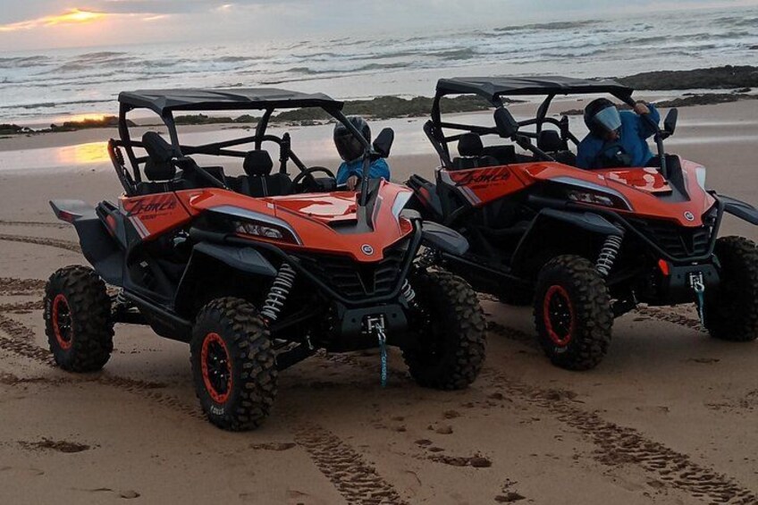 Two ATVs on a sandy beach with the ocean in the background. 2