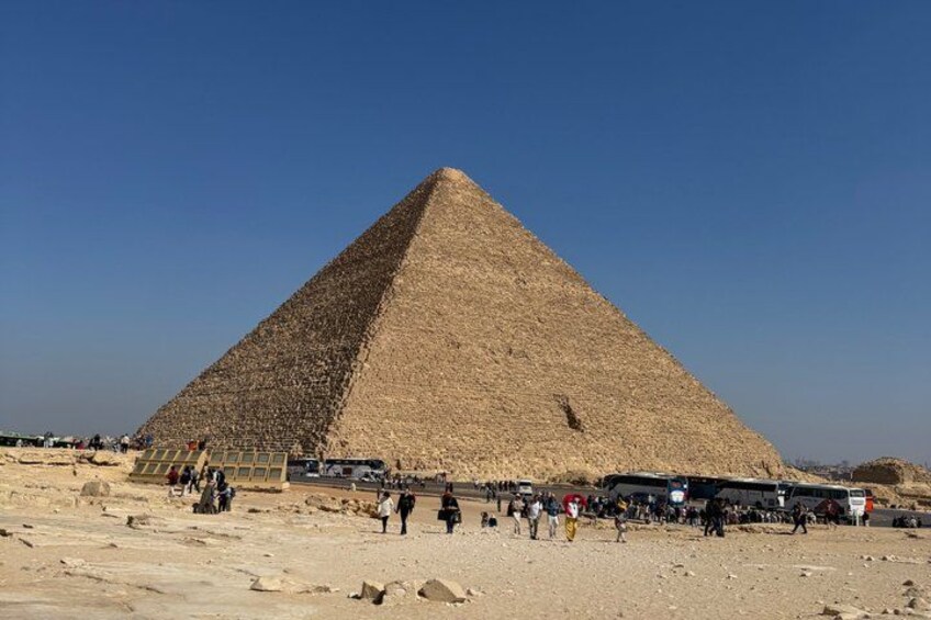 A large pyramid with tourists around it. 4